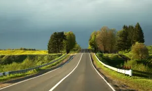 Droga pnie się ku niebu, otoczona zielenią i żółtym polem. Zrid, podróż trwa.