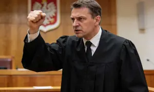 Sędzia z zaciętą miną podnosi pięść, symbolizując walkę o sprawiedliwość w sprawie skarga pauliańska.