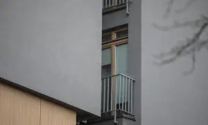 Szare bloki, wąskie okna i balkon z kolcami na ptaki – typowa patodeweloperka.