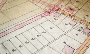 Stara mapa ewidencyjna z zaznaczonymi działkami i budynkami. Widoczne numery działek i wymiary.