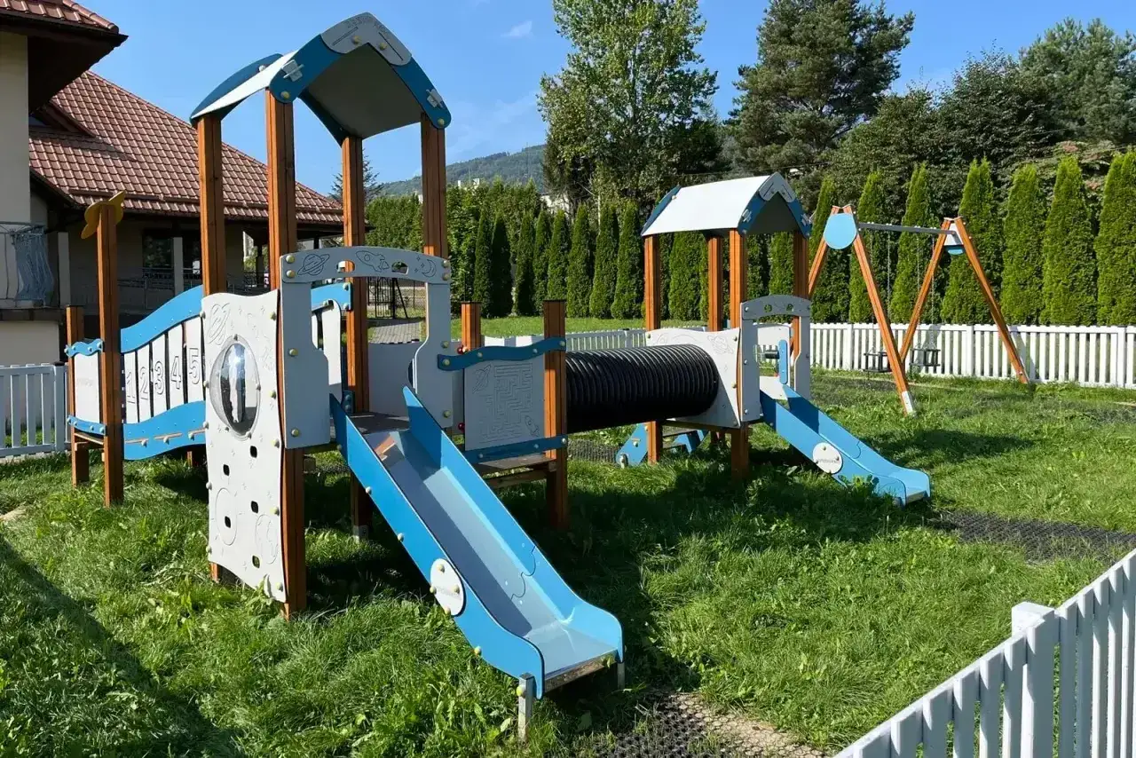 Kolorowy plac zabaw z tunelem i zjeżdżalniami. Czy plac zabaw wymaga pozwolenia na budowę? Zależy od jego wielkości i lokalizacji.