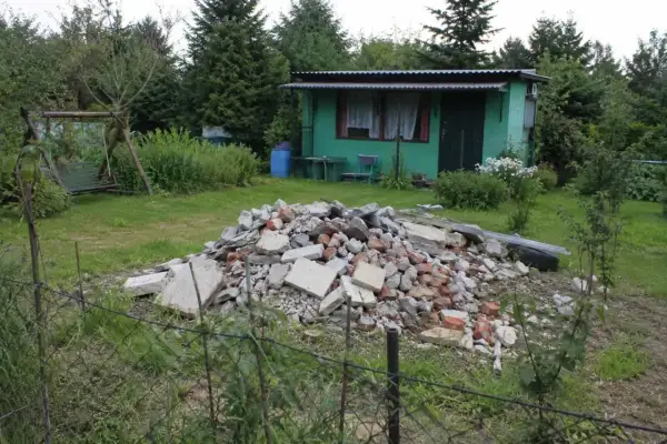 Ziemia na sprzedaż! Gruz i śmieci na działce z domkiem i huśtawką.