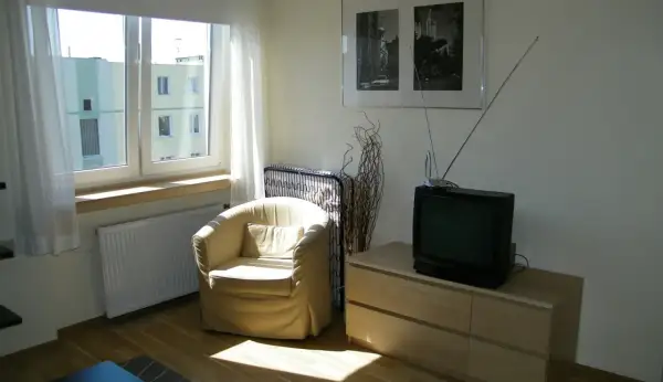 Stary telewizor i fotele, pamiątka po dziadkach, symbolizują dziedziczenie.